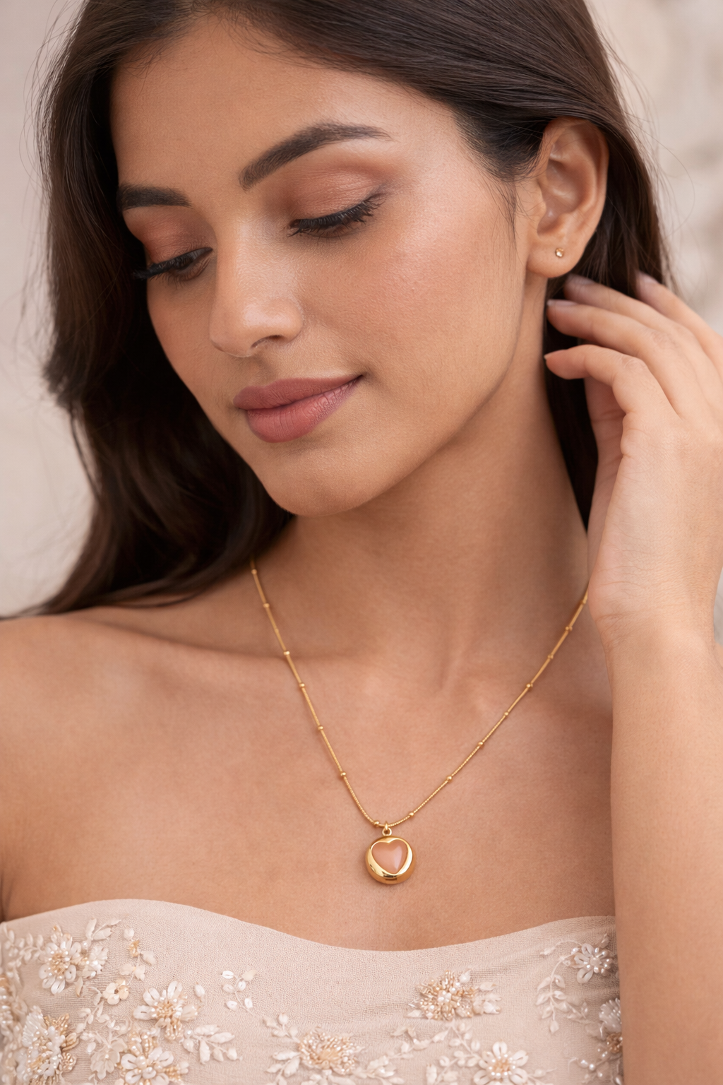 Woman wearing Sivorae steel golden heart pendant necklace with peach stone elegant jewelry for her