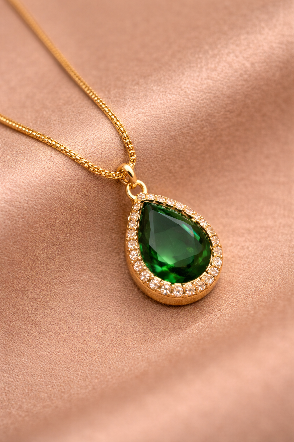 Close-up of Sivorae green teardrop gemstone pendant necklace with gold finish and cubic zirconia halo